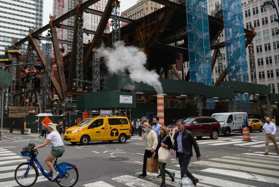 People walk past a new building construction site in midtown Manhattan. 