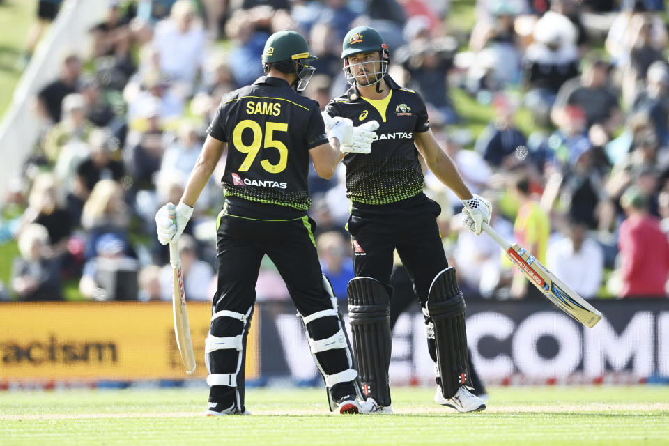 Australia's Daniel Sams, left, teammate Marcus Stoinis react during the second T20 cricket international between Australia and New Zealand at University Oval In Dunedin, New Zealand, Thursday, Feb. 25, 2021. (Andrew Cornaga/Photosport via AP)