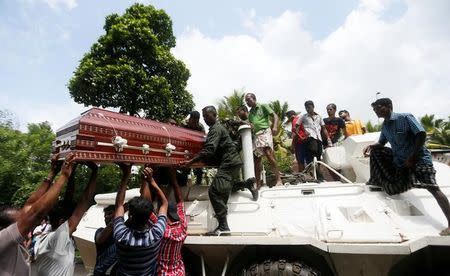 People help military officials load the coffin of a victim who died in a landslide in Bulathsinhala village, in Kalutara, Sri Lanka May 27, 2017. REUTERS/Dinuka Liyanawatte