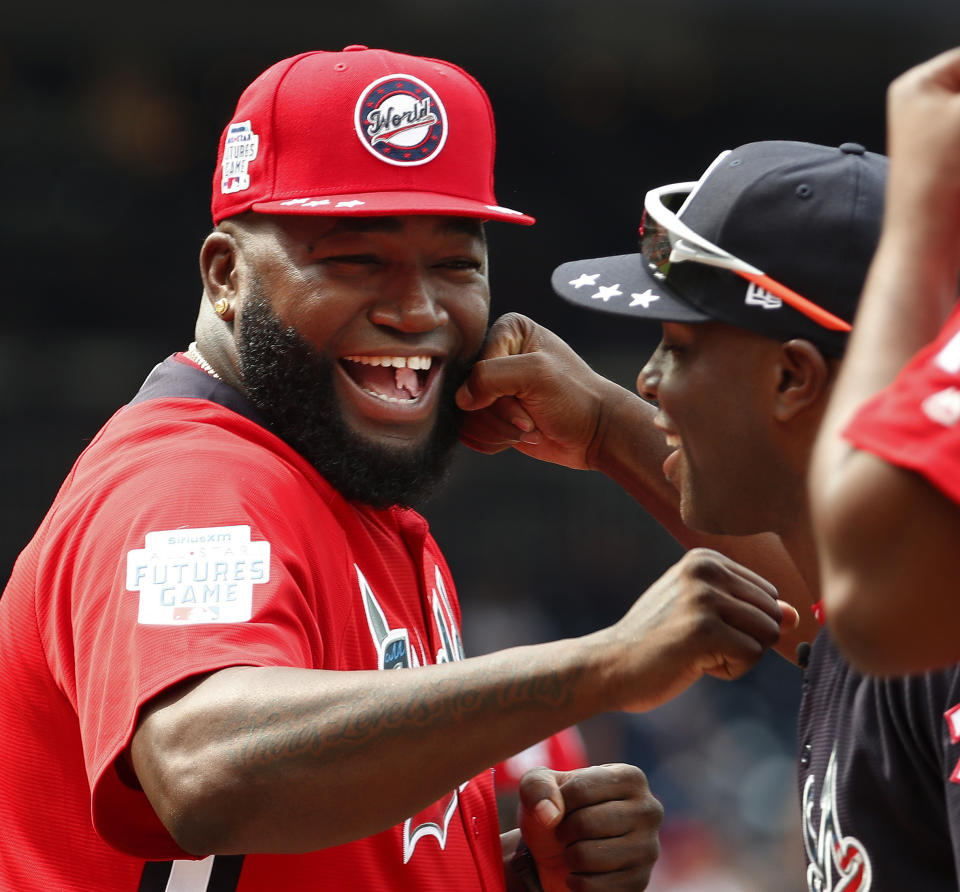 FILE - In this July 15, 2018, file photo, World Team Manager David Ortiz (34) speaks with U.S. Team Manager Torrii Hunter, before the All-Star Futures baseball game at Nationals Park, in Washington. Ortiz returned to Boston for medical care after being shot in a bar Sunday, June 9, 2019, in his native Dominican Republic. (AP Photo/Alex Brandon, File)