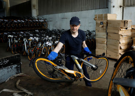 Zhivko Girginov, a Bulgarian living in Singapore, return damaged Obikes to their warehouse after gathering them around his neighbourhood in Singapore December 29, 2017. Picture taken December 29, 2017. REUTERS/Edgar Su