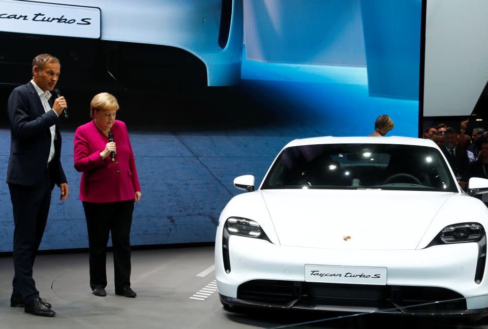 Porsche AG CEO Oliver Blume and German Chancellor Angela Merkel speak next to Porsche Taycan Turbo S at the international Frankfurt Motor Show IAA in Frankfurt, Germany September 12, 2019. REUTERS/Ralph Orlowski