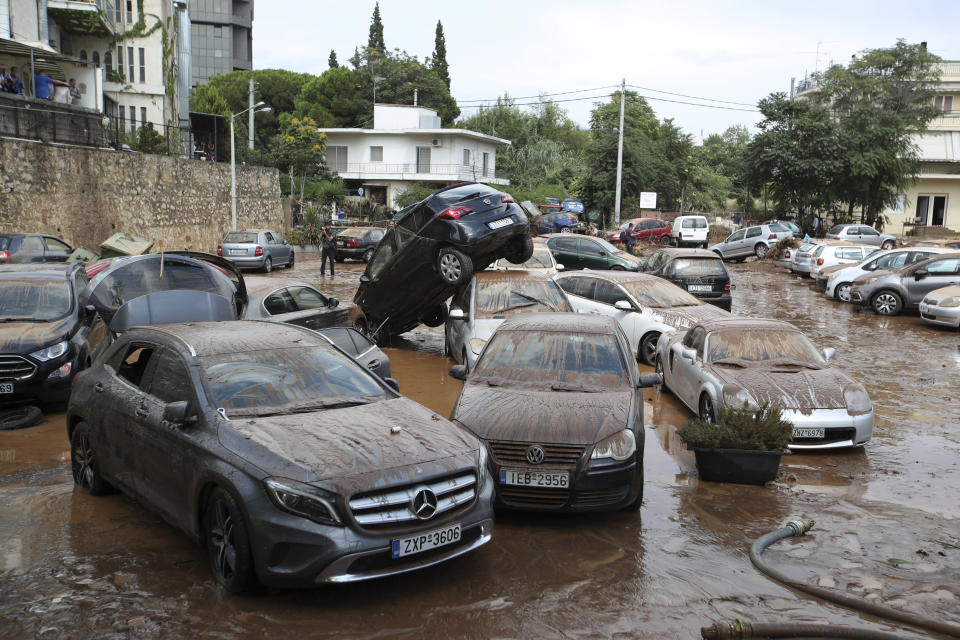 Damaged cars are strewn across an open parking area in northern Athens, Thursday, July 26, 2018 after flash floods caused by a sudden downpour. (AP Photo/Thanassis Stavrakis)