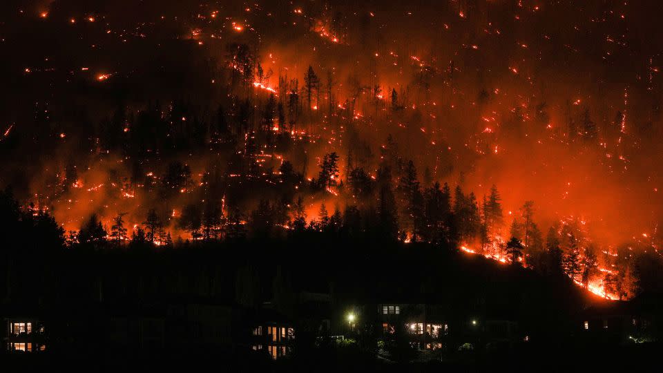 The McDougall Creek wildfire burns on the mountainside above houses in West Kelowna on Friday. - Darryl Dyck/The Canadian Press/AP