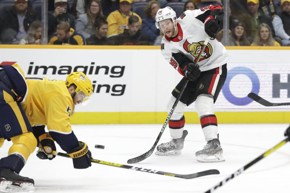 Ottawa Senators right wing Connor Brown, right, passes the puck past Nashville Predators defenseman Ryan Ellis, left, in the first period of an NHL hockey game Tuesday, Feb. 25, 2020, in Nashville, Tenn. (AP Photo/Mark Humphrey)