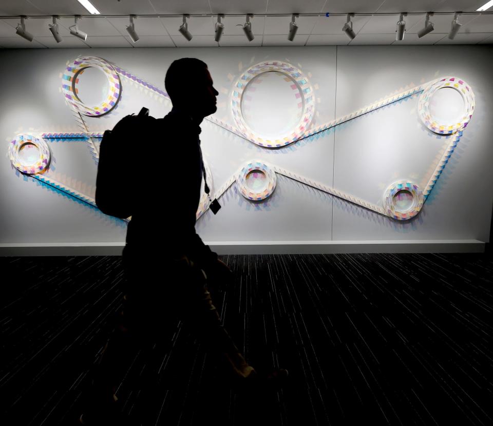 An employee walks past one of several art installations on the walls at the General Motors Cole Engineering Center at the Warren Technical Center In Warren on Dec 7, 2022.