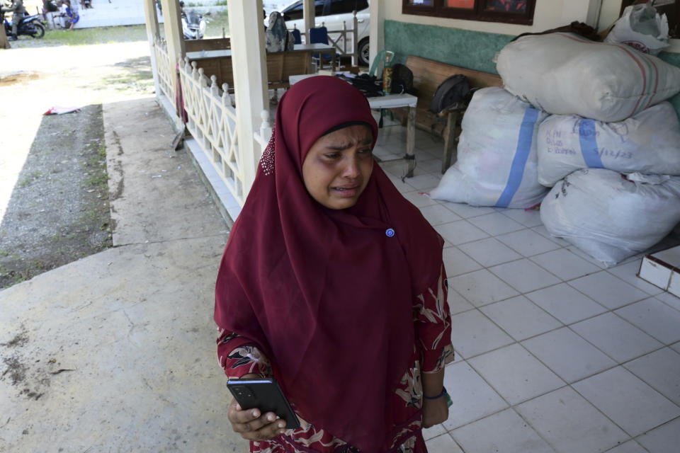 Fatima Khatun, a Rohingya survivor of a capsized refugee boat, cries as she calls her son in Bangladesh from a temporary shelter in Meulaboh, Indonesia, on Wednesday, April 3, 2024. Fatima was among 75 people rescued in March from atop the overturned hull of the boat. Dozens of others, including Fatima's 8-year-old daughter, died. (AP Photo/Reza Saifullah)