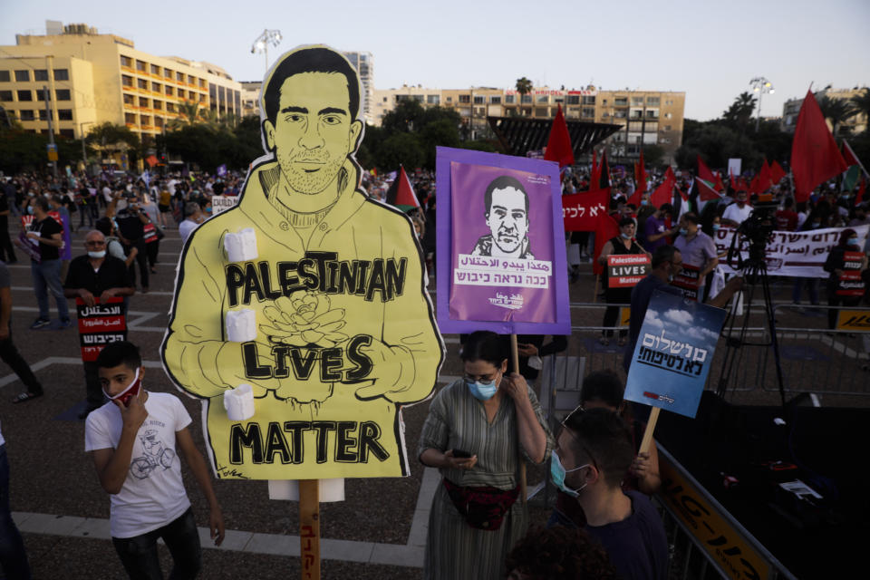 Protesters attenda rally against Israel plans to annex parts of the West Bank, in Tel Aviv, Israel, Saturday, June 6, 2020. The drawing represents Eyad Hallaq, a Palestinian with severe autism who was killed recently by Israeli border police officers after a chase in Jerusalem's Old City after apparently being mistaken as an attacker. (AP Photo/Sebastian Scheiner)