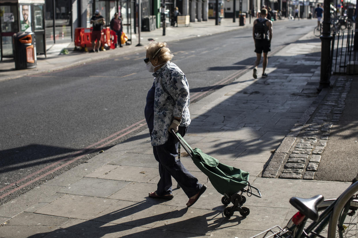 LONDON, ENGLAND - JUNE 01: An elderly woman wearing a face mask walks in Clapham on June 01, 2020 in London, England. The British government further relaxed Covid-19 quarantine measures in England this week, allowing groups of six people from different households to meet in parks and gardens, subject to social distancing rules. Many schools also reopened and vulnerable people who are shielding in their homes are allowed to go outside again. (Photo by Dan Kitwood/Getty Images)