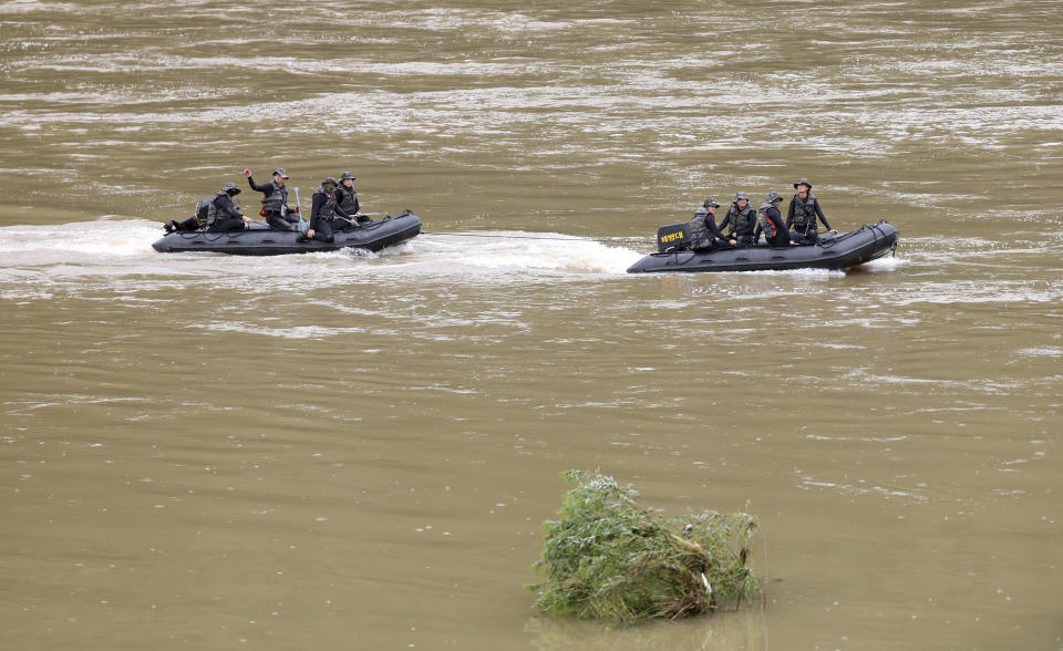 South Korean marines on boats search for missing people in the Sam River in Yecheon, South Korea, Tuesday, July 18, 2023. Rescuers continued their searches Tuesday for people still missing in landslides and other incidents caused by more than a week of torrential rains. (Kim Dong-min/Yonhap via AP)