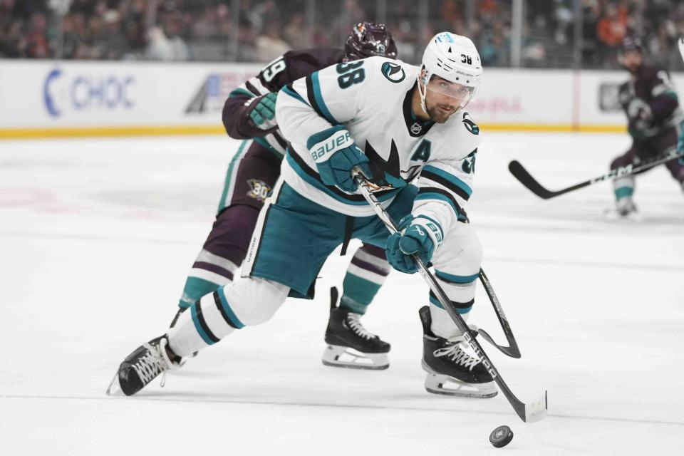 San Jose Sharks' Mario Ferraro (38) moves the puck under pressure by Anaheim Ducks' Troy Terry (19) during the first period of an NHL hockey game Sunday, Nov. 12, 2023, in Anaheim, Calif. (AP Photo/Jae C. Hong)