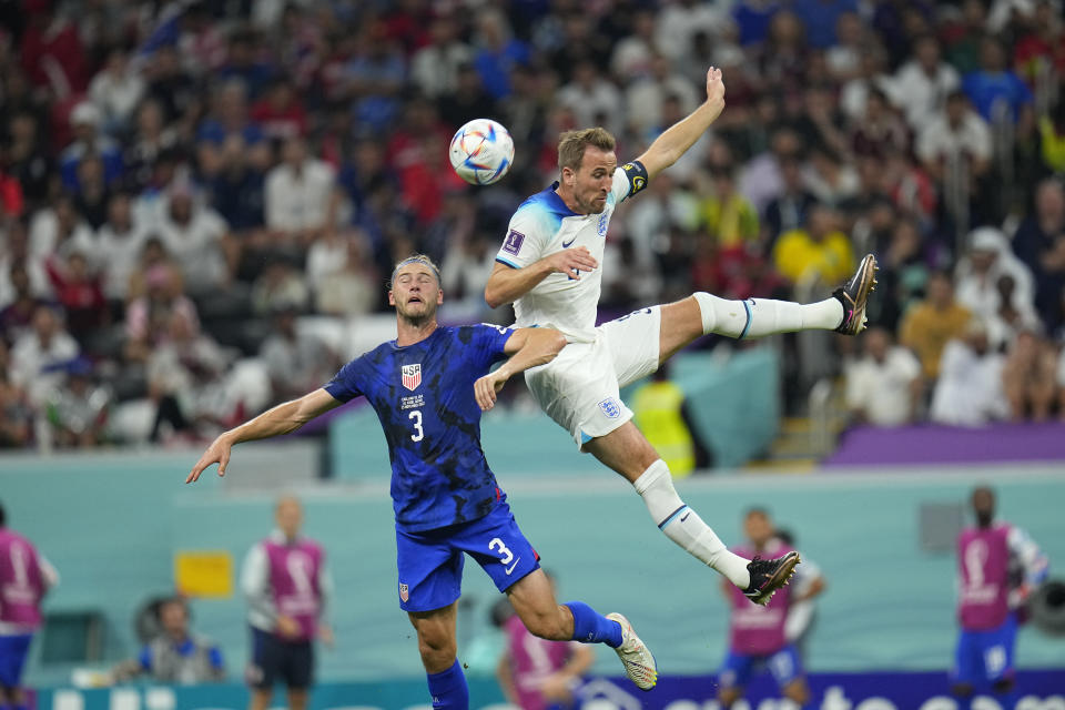 El estadounidense Walker Zimmerman (izquierda) pugna por el balón con el atacante inglés Harry Kane en el partido por el Grupo B del Mundial, el viernes 25 de noviembre de 2022, en Jor, Qatar. (AP Foto/Julio Cortez)