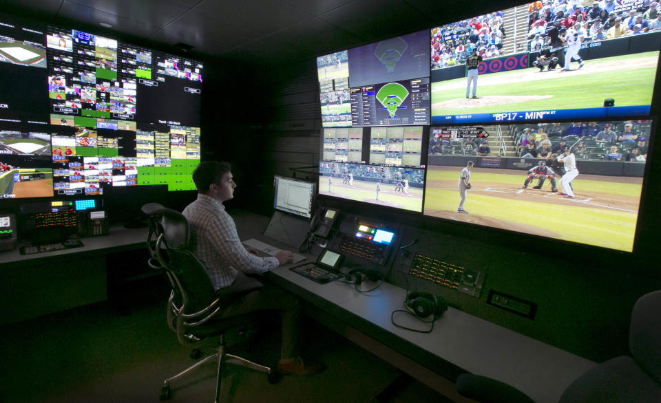 A technician works in front of a bank of television screens during a preview of Major League Baseball's Replay Operations Center, in New York, Wednesday, March 26, 2014. Less than a week before most teams open, MLB is working on the unveiling of its new instant replay system, which it hopes will vastly reduce incorrect calls by umpires. (AP Photo/Richard Drew)