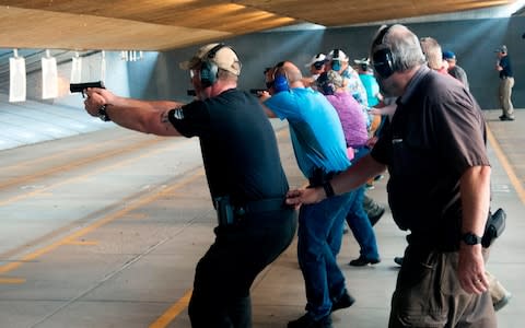 School teachers and administrators fire their guns while conducting a drill - Credit:  JASON CONNOLLY/AFP