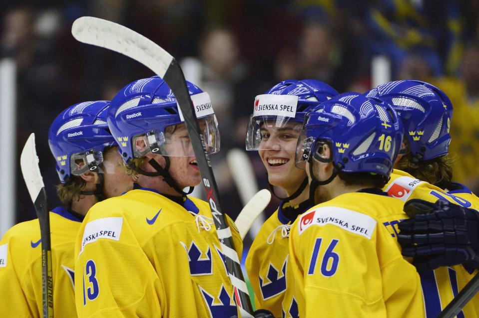 Sweden's Andre Burakowsky (C) celebrates with teammates Gustav Olofsson (13) and Filip Forsberg (16) after scoring against Norway during their IIHF World Junior Championship Group B preliminary round ice hockey match at Malmo Arena in Malmo, December 29, 2013. REUTERS/Ludvig Thunman/TT News Agency (SWEDEN - Tags: SPORT ICE HOCKEY) ATTENTION EDITORS - THIS IMAGE HAS BEEN SUPPLIED BY A THIRD PARTY. IT IS DISTRIBUTED, EXACTLY AS RECEIVED BY REUTERS, AS A SERVICE TO CLIENTS. SWEDEN OUT. NO COMMERCIAL OR EDITORIAL SALES IN SWEDEN. NO COMMERCIAL SALES