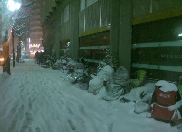 Snow-covered customers await opening of the Sapporo, Japan Apple Store