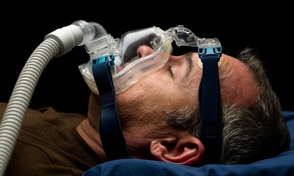 <span>The standard treatment for obstructive sleep apnoea is sleeping with a machine that blows air through a face mask to keep the airways open.</span><span>Photograph: Juanmonino/Getty Images</span>