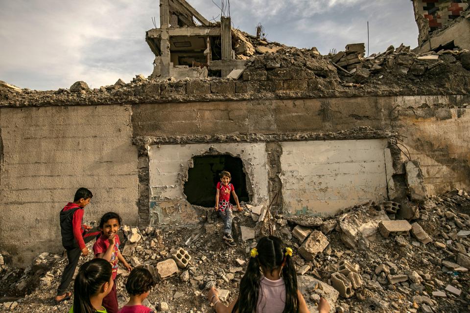 Children play amidst debris in the northern Syrian city of Raqa, the former Syrian capital of the Islamic State (IS) group, on May 1, 2019. - The Kurdish-led Syrian Democratic Forces overran Raqa in 2017, after years of what residents described as IS's brutal rule, which included public beheading and crucifixions. (Photo by Delil souleiman / AFP)        (Photo credit should read DELIL SOULEIMAN/AFP/Getty Images)