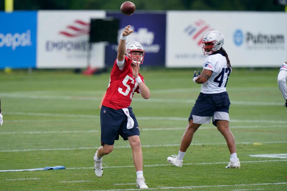 New England Patriots quarterback Mac Jones (50) passes the ball as fullback Jakob Johnson (47) looks on during an NFL football minicamp practice, Tuesday, June 15, 2021, in Foxborough, Mass.