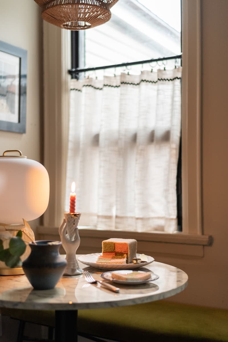 Cake on a stone dining table in a white kitchen.