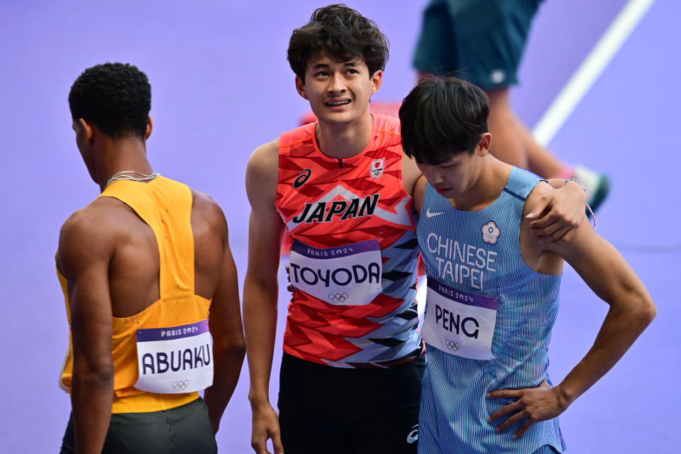 彭名揚無法完賽，日本選手TOYODA Ken給予鼓勵。 (Photo by Martin  BERNETTI / AFP) (Photo by MARTIN  BERNETTI/AFP via Getty Images)