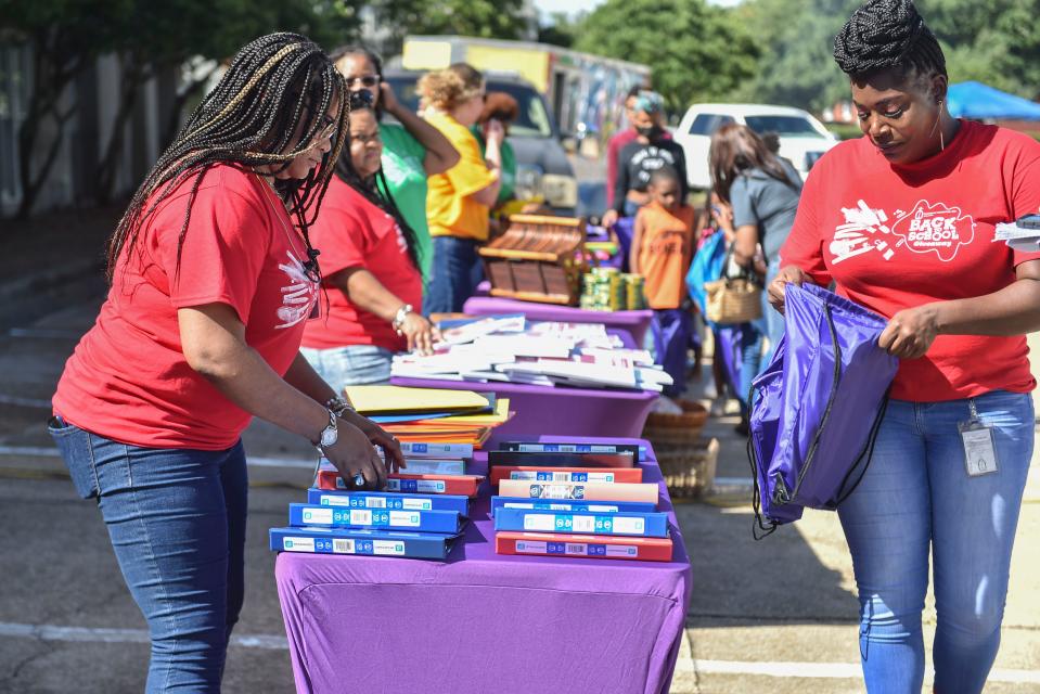 Rachel Travis (right), coordinator of the Catholic Charities, Inc. school supply giveaway is seen in Jackson on Friday. The giveaway provides access to school supplies for locals in the community.