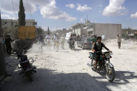 Residents inspect a site hit by what activists said were airstrikes carried out by the Russian air force in Kafranbel, near Idlib Syria October 10, 2015. REUTERS/Khalil Ashawi