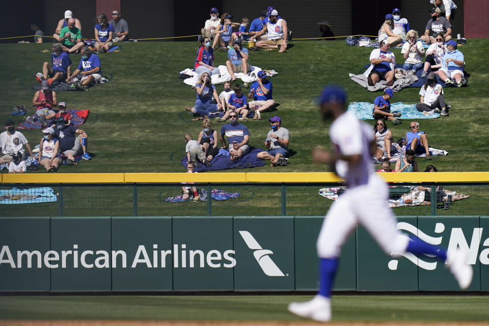 Socially distanced fans watch as Chicago Cubs right fielder Jason Heyward, foreground, head toward the dugout after the second inning of a spring baseball game against the Kansas City Royals in Mesa, Ariz., Tuesday, March 2, 2021. (AP Photo/Jae C. Hong)