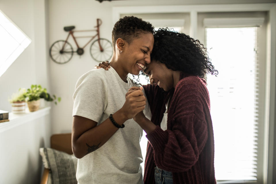 Two people sharing a joyful moment with a forehead touch, expressing affection