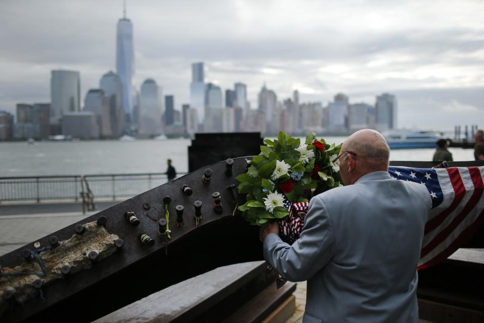 A man places a wreath at the 9/11 memorial during the 13th anniversary of the 9/11 attacks on the World Trade Center, in Exchange Place, New Jersey, September 11, 2014. Until a few months ago, the part of New York City where crowds will gather on Thursday morning to mark the 13th anniversary of the September 11 attacks on the United States had been mostly fenced off to the public.This year, for perhaps the first time since the attacks, a sense of normalcy and openness has taken root in the city blocks where two airliners hijacked by militants from al Qaeda crashed into the World Trade Center's twin towers. (REUTERS/Eduardo Munoz)