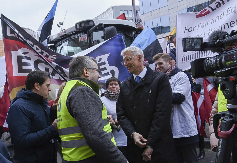 Latvian Prime Minister Krisjanis Karins, center right, speaks with farmers from the Baltic's as they demonstrate outside of an EU summit in Brussels, Thursday, Feb. 20, 2020. Baltic farmers on Thursday were calling for a fair allocation of direct payments under the European Union's Common Agricultural Policy. (AP Photo/Riccardo Pareggiani)