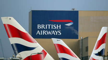 FILE PHOTO: British Airways logos are seen on tail fins at Heathrow Airport in west London, Britain, February 23, 2018. REUTERS/Hannah McKay