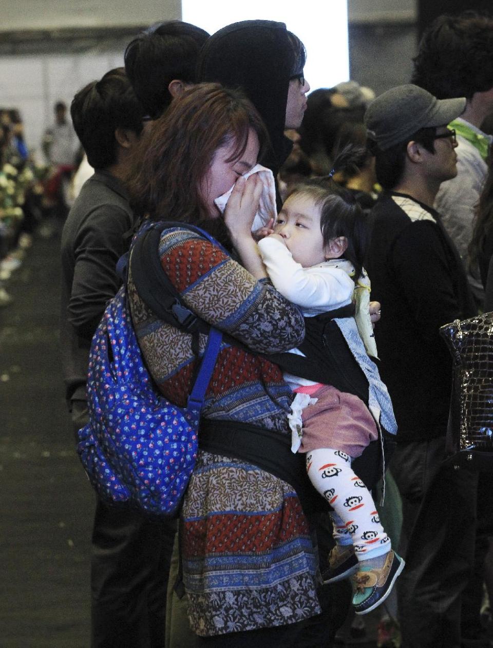 A woman weeps as she pays tribute to the victims of the sunken ferry Sewol at a group memorial altar in Ansan, South Korea, Sunday, May 4, 2014. Divers battled strong currents and wind Saturday to search unopened rooms in the sunken South Korean ferry for dozens of missing passengers, officials said Saturday. (AP Photo/Ahn Young-joon)