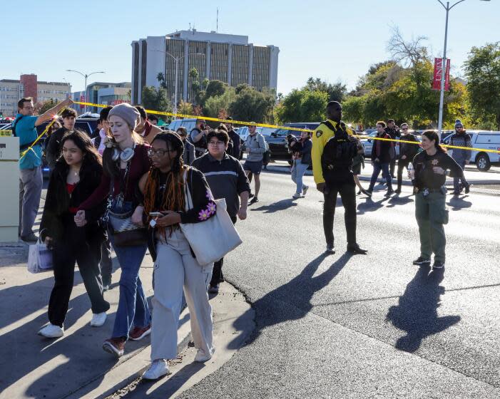 LAS VEGAS, NEVADA - DECEMBER 06: People cross Maryland Parkway as they are led off of the UNLV campus after a shooting on December 06, 2023 in Las Vegas, Nevada. According to Las Vegas Metro Police, a suspect is dead and multiple victims are reported after a shooting on the campus. (Photo by Ethan Miller/Getty Images)