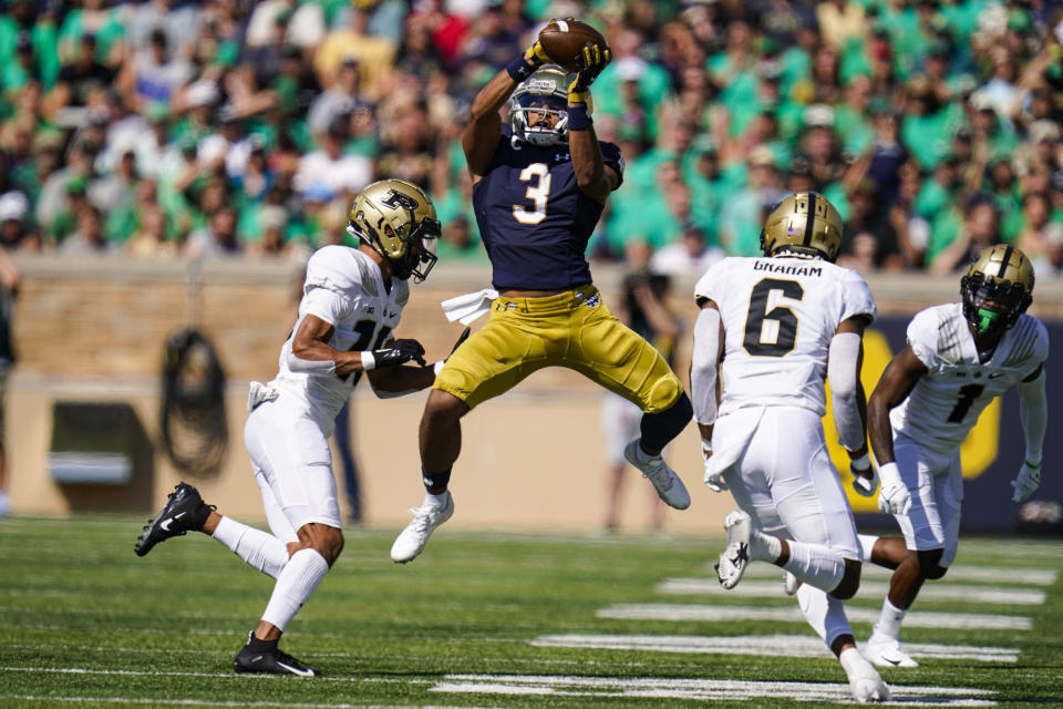 Notre Dame wide receiver Avery Davis (3) makes a catch between Purdue safety Cam Allen (10) and linebacker Jalen Graham (6) during the first half of an NCAA college football game in South Bend, Ind., Saturday, Sept. 18, 2021. (AP Photo/Michael Conroy)
