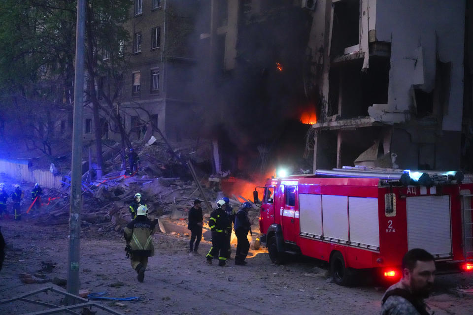 Firefighters put out a fire after a Russian rocket attack in Kyiv, Ukraine, Thursday, April 28, 2022. Russia mounted attacks across a wide area of Ukraine on Thursday, bombarding Kyiv during a visit by the head of the United Nations. (AP Photo/Efrem Lukatsky)