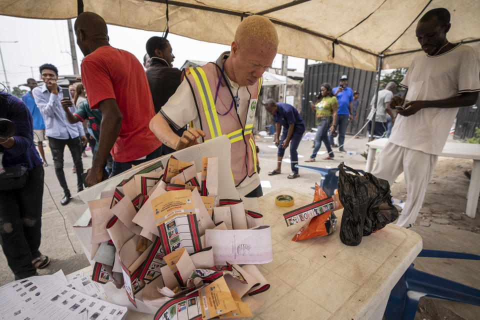 An electoral worker looks at what materials are left moments after armed men fired shots and drove off with the ballot boxes at a polling station in Lagos, Nigeria Saturday, Feb. 25, 2023. Voters in Africa's most populous nation are heading to the polls Saturday to choose a new president, following the second and final term of incumbent Muhammadu Buhari. (AP Photo/Ben Curtis)