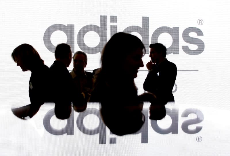 FILE PHOTO: Shareholders of Adidas Group silhouetted in front of the company logo in Fuerth near Nuremberg, Germany, May 8, 2008. REUTERS/Michaela Rehle/File Photo