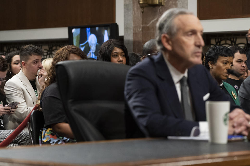 Sam Amato, left, of Buffalo, N.Y., who is a member of the Union and says he was illegally fired from Starbucks after 13 years, becomes emotional during testimony by former Starbucks CEO Howard Schultz, at right, before the Senate Health, Education, Labor and Pensions committee, Wednesday, March 29, 2023, on Capitol Hill in Washington. (AP Photo/Jacquelyn Martin)