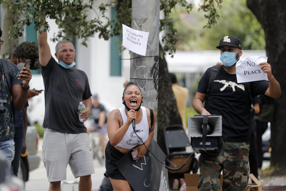 A demonstrator rallies people protesting the death of George Floyd, a handcuffed black man who died in the custody of the police in Minneapolis, on a street corner in New Orleans, Friday, May 29, 2020. (AP Photo/Gerald Herbert)