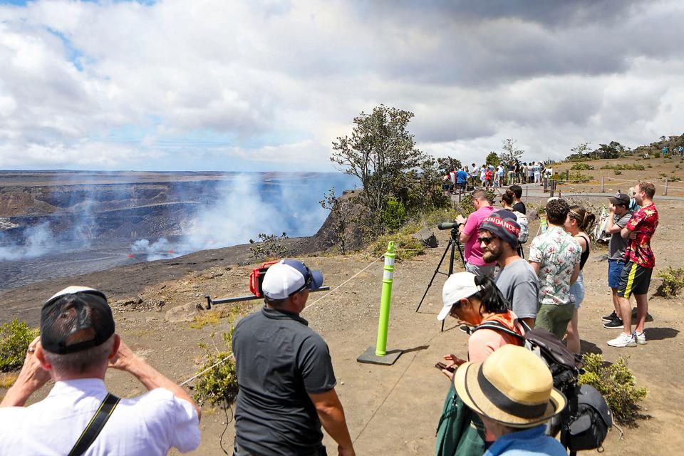 Visitors line the side of an overlook to view the Kilauea eruption in Hawaii on Wednesday, June 7, 2023. Hawaii tourism officials are urging tourists to be respectful when flocking to a national park on the Big Island to get a glimpse of the latest eruption of Kilauea. It's one of the world's most active volcanoes and began erupting after a three-month pause. (Kelsey Walling/Hawaii Tribune-Herald via AP) ORG XMIT: HIHIO401