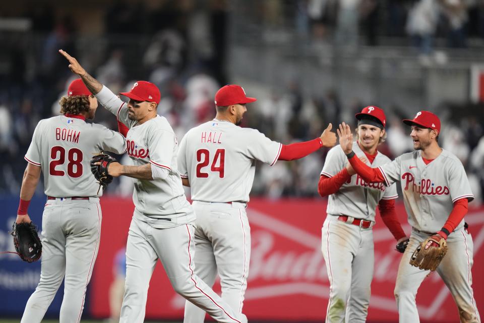Philadelphia Phillies' Alec Bohm (28) and Darick Hall (24) celebrate with teammates after a baseball game against the New York Yankees Tuesday, April 4, 2023, in New York. The Phillies won 4-1. (AP Photo/Frank Franklin II)