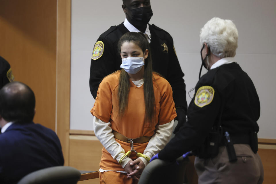 Kayla Montgomery, center, stepmother of missing girl Harmony Montgomery, is escorted into Hillsborough County Superior Court North, in Manchester, N.H., Monday, Jan. 24, 2022, where she pleaded not guilty to charges accusing her of lying last year that Harmony was in her household to claim food stamp benefits. (Jessica Rinaldi/The Boston Globe via AP, Pool)