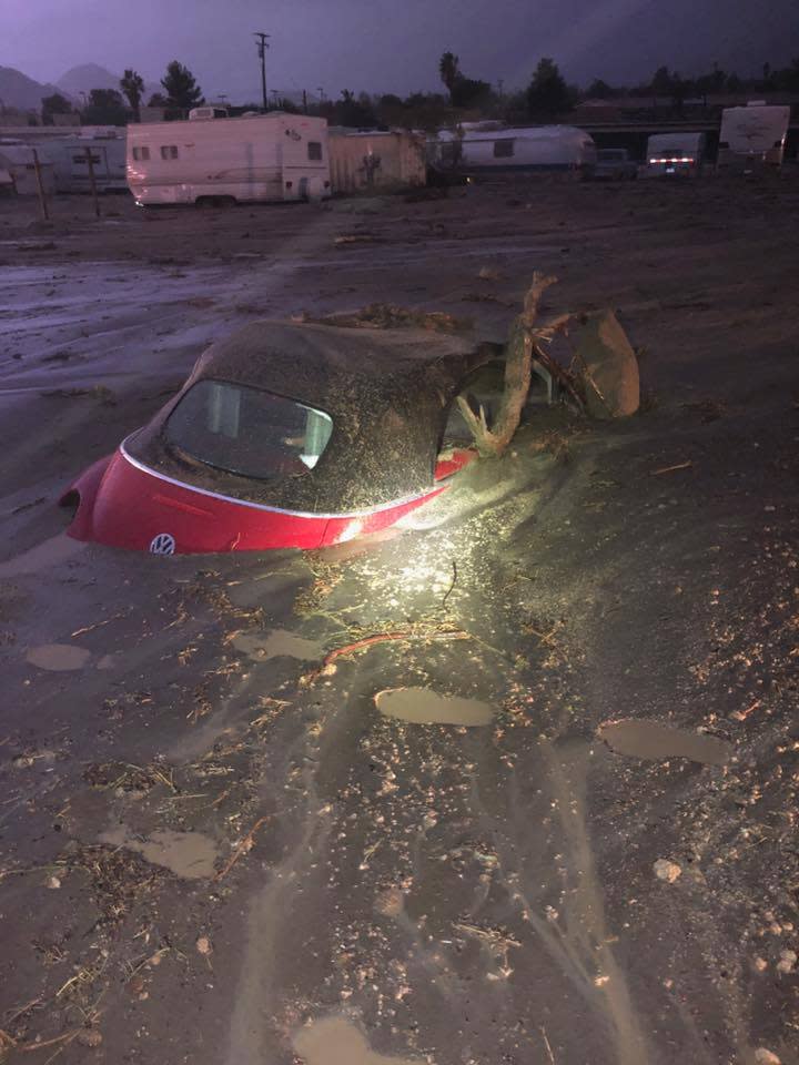 Mudslides in Orange County Wednesday trapped cars, like this Volkswagen partially submerged during an unrelated mudslide on Highway 62 in Joshua Tree.