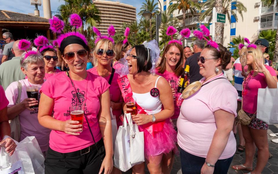 Group of young British women on a hen weekend having fun at waterfront bar in Benidorm, Spain - Getty Images