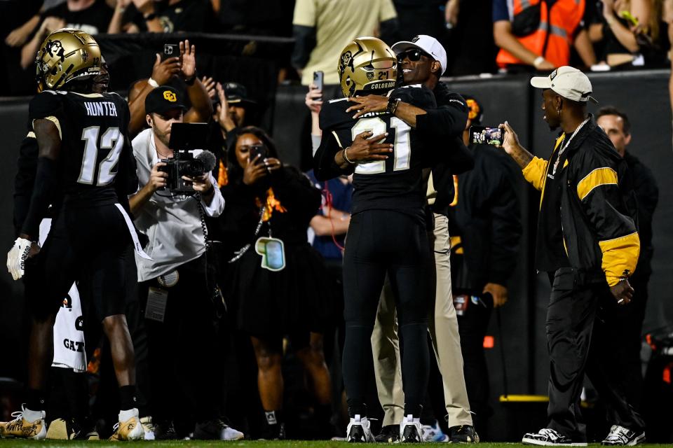 Safety Shilo Sanders of the Colorado Buffaloes celebrates with head coach Deion Sanders after scoring a touchdown after an interception against the Colorado State.