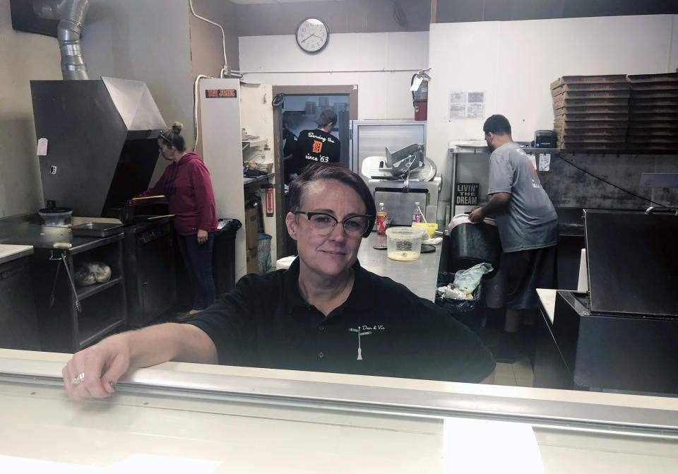 Tina Wheeler, manager of Dan and Vi's pizza poses for a photo, Thursday, Oct. 10, 2019 in Detroit. Dan and Vi’s pizza deli, one of the few eateries near the Detroit-Hamtramck General Motors plant, says sales have been down, though Wednesday’s noontime crowd snaked around the small shop nearly to the door. “We’re definitely noticing a difference in sales, but we’re gonna be OK,” said manager Tina Wheeler. “We’ve been in the neighborhood 56 years. We’re not going anywhere.” (AP Photo/Corey Williams)