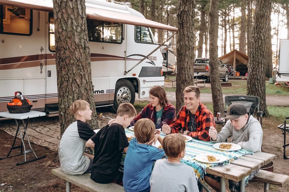 the walker family eating at a table outside in front of their RV