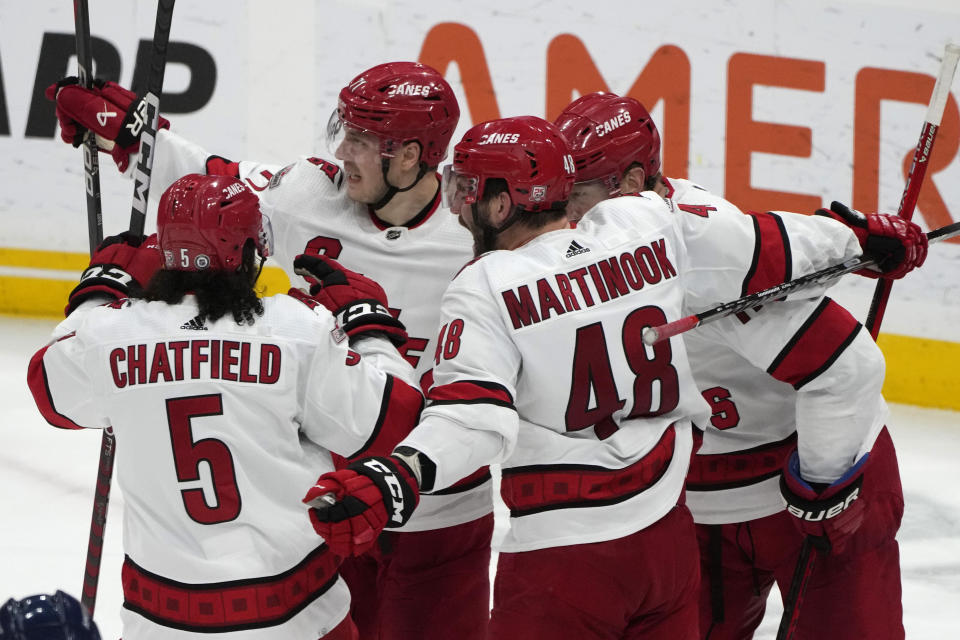 Carolina Hurricanes right wing Jesper Fast, center, celebrates with Jalen Chatfield (5) and Jordan Martinook (48) after scoring during the third period of an NHL hockey game against the Florida Panthers, Thursday, April 13, 2023, in Sunrise, Fla. (AP Photo/Lynne Sladky)