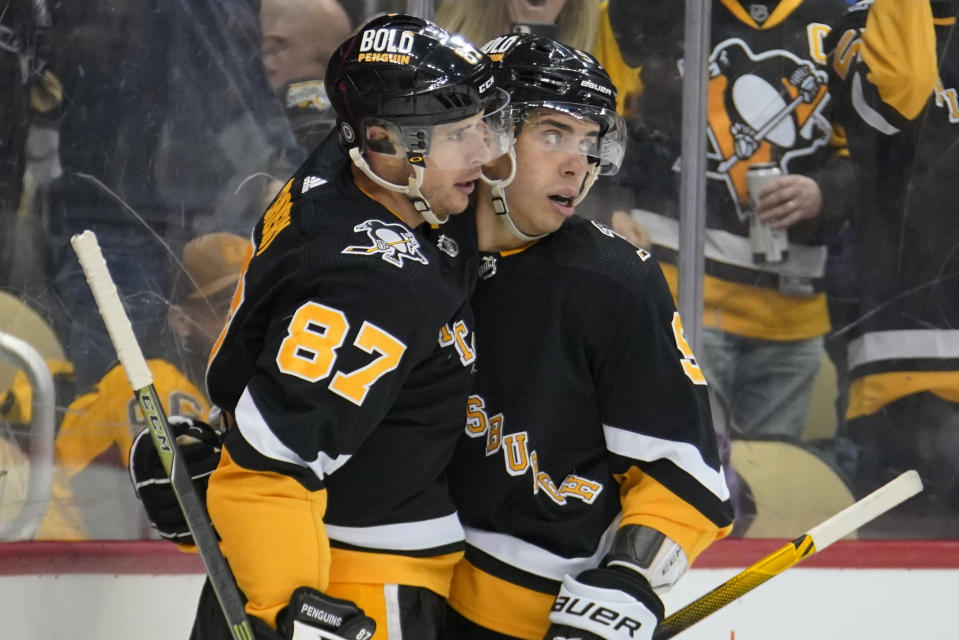 Pittsburgh Penguins' Sidney Crosby (87) celebrates his goal with Evan Rodrigues during the second period of an NHL hockey game against the Detroit Red Wings in Pittsburgh, Sunday, March 27, 2022. (AP Photo/Gene J. Puskar)